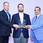 José Ruben Gonell Cosme, acompañado de Daniel Peña, viceministro de Industria Comercio y Mipymes (MICM), entrega una placa Orlando Jorge Villegas en hono0r a su padre Orlando Jorge Mera, en el homenaje póstumo que le fue rendido.